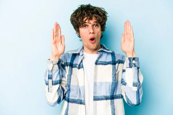 Kafkasyalı genç bir adam mavi arka planda izole edilmiş. Bir fikri, ilham verici bir fikri var..