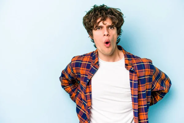 Kafkasyalı genç adam mavi arka planda izole edilmişti. Gördüğü bir şey yüzünden şok olmuştu..