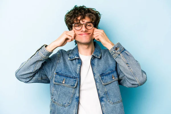 Kafkasyalı genç adam mavi arka planda izole edilmiş iki seçenek arasında şüphe duyuyor.