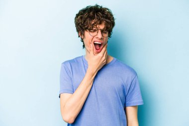 Mavi arka planda izole genç beyaz adam güçlü bir diş ağrısı, azıdişi ağrısı var..