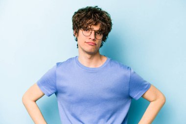 Kafkasyalı genç adam mavi arka planda izole edilmiş üzgün, ciddi yüzlü, mutsuz ve hoşnutsuz..
