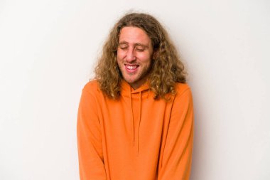 Beyaz arka planda izole edilmiş genç beyaz adam gülüyor ve gözlerini kapıyor, rahatlamış ve mutlu hissediyor..