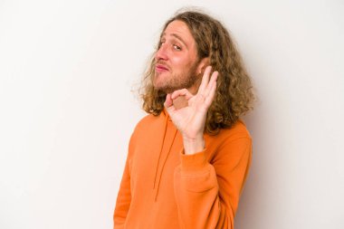 Beyaz arka planda izole edilmiş genç beyaz bir adam bir göz kırptı ve elleriyle iyi bir jest yaptı..