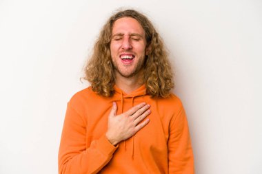 Beyaz arka planda izole genç beyaz adam yüksek sesle gülüyor elini göğsüne koyuyor..