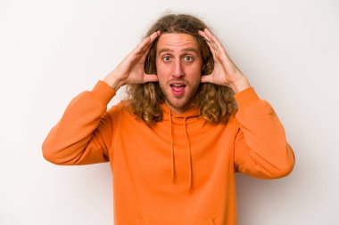 Beyaz arka planda izole genç beyaz adam hoş bir sürpriz alıyor, heyecanlı ve el kaldırıyor..