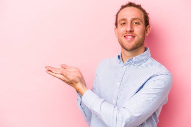 Pembe arka planda izole edilmiş beyaz bir adam elinde bir fotokopi odası tutuyor..