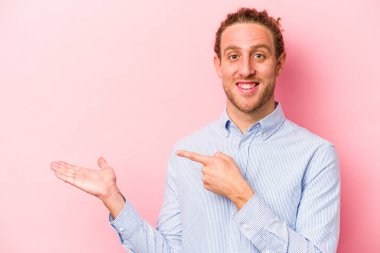 Pembe arka planda izole edilmiş beyaz bir adam. Elinde bir fotokopi odası tutarken heyecanlı..