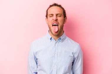 Genç, beyaz bir adam pembe arka planda izole edilmiş komik ve dost canlısı bir dil kullanıyor..