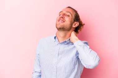 Pembe arka planda izole edilmiş genç beyaz adam kollarını uzatıyor, rahat bir konumda..