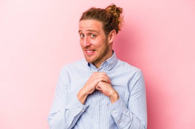 Pembe arka planda izole edilmiş genç beyaz adam korkmuş ve korkmuş..