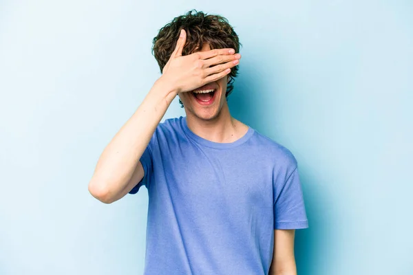 Mladý Běloch Izolovaný Modrém Pozadí Zakrývá Oči Rukama Usmívá Čeká — Stock fotografie