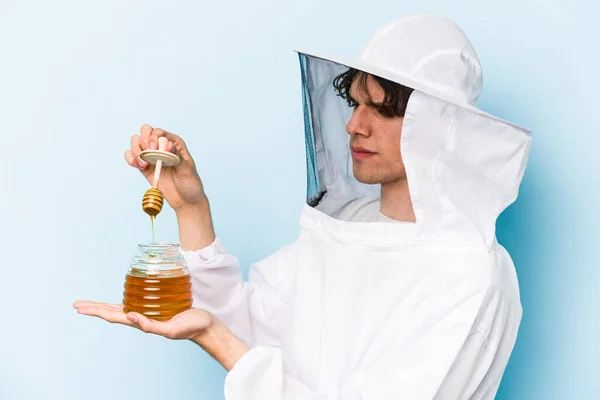 Young Caucasian Beekeeper Man Holding Honey Isolated Blue Background — Fotografia de Stock
