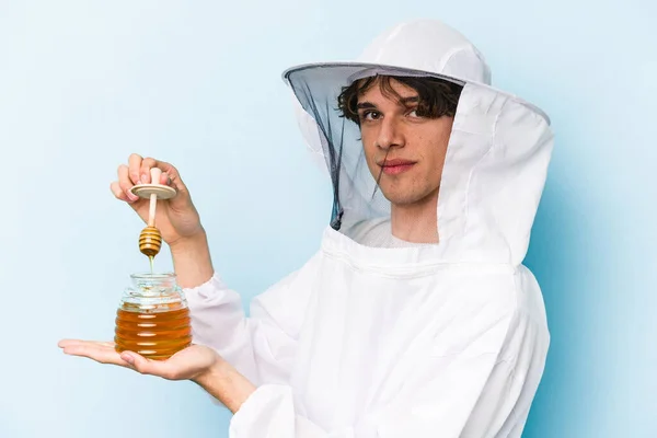 Young Caucasian Beekeeper Man Holding Honey Isolated Blue Background — Stock Photo, Image