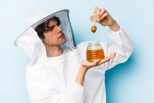 Young Caucasian Beekeeper Man Holding Honey Isolated Blue Background — Stock Photo, Image