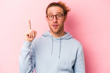 Pembe arka planda soyutlanmış genç beyaz bir adamın bir fikri var, ilham verici bir kavram..