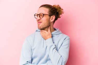 Pembe arka planda izole edilmiş genç beyaz adam virüs veya enfeksiyon yüzünden boğazında ağrı hissediyor..