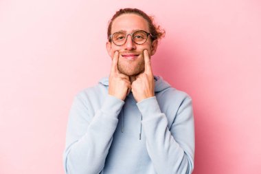 Pembe arka planda izole edilmiş beyaz bir adam iki seçenek arasında şüphe duyuyor..