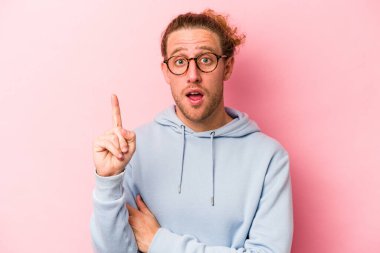 Pembe arka planda soyutlanmış genç beyaz bir adam. Harika bir fikri var, yaratıcılık kavramı..