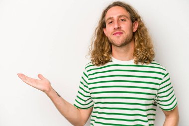 Beyaz arka planda izole edilmiş genç beyaz bir adam bir palmiye üzerinde fotokopi alanı gösteriyor ve belinde başka bir el tutuyor..