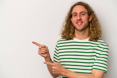 Beyaz arka planda izole edilmiş genç beyaz bir adam işaret parmağıyla işaret ettiği için heyecanlı..