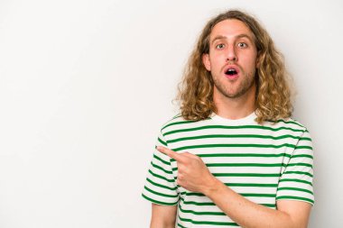 Beyaz arka planda izole edilmiş genç beyaz adam yan tarafı işaret ediyor