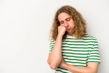 Beyaz arka planda izole edilmiş, üzgün ve dalgın hisseden genç beyaz bir adam fotokopi alanına bakıyor..