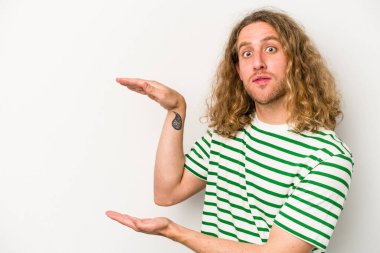 Beyaz arka planda izole edilmiş genç beyaz adam elleri arasında bir kopya alanı tutarken şok ve hayrete düştü..