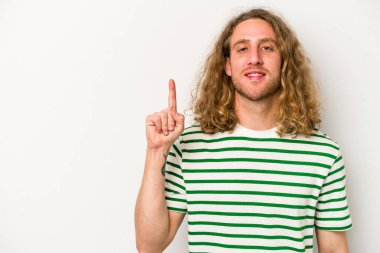 Beyaz arka planda izole edilmiş beyaz tenli genç bir adam bir numarayı parmağıyla gösteriyor..