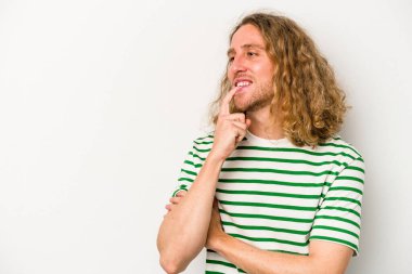 Beyaz arka planda izole edilmiş genç beyaz bir adam rahatlamış bir şeyin fotokopi odasına baktığını düşünüyor..