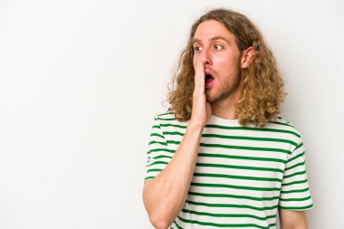 Beyaz arka planda izole edilmiş genç beyaz bir adam gizli bir sıcak fren haberi veriyor ve yana bakıyor.