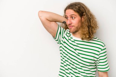 Beyaz arka planda izole edilmiş genç beyaz bir adam kafasının arkasına dokunuyor, düşünüyor ve bir seçim yapıyor..