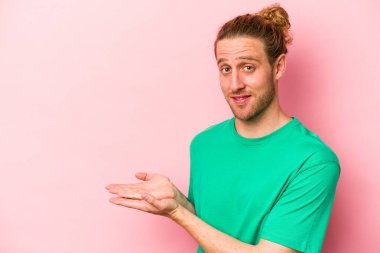 Pembe arka planda izole edilmiş beyaz bir adam elinde bir fotokopi odası tutuyor..