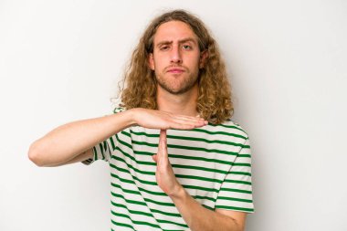 Beyaz arka planda izole edilmiş genç beyaz bir adam bir mola hareketi gösteriyor..