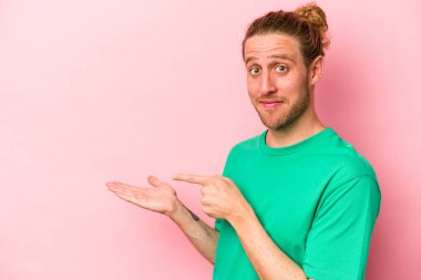 Pembe arka planda izole edilmiş beyaz bir adam. Elinde bir fotokopi odası tutarken heyecanlı..