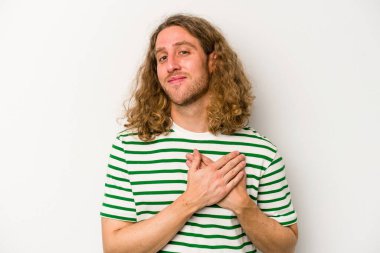 Beyaz arka planda izole edilmiş beyaz tenli genç bir adam, dostane bir ifadeye sahip, avuçlarını göğsüne bastırıyor. Aşk konsepti.