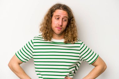 Beyaz arka planda soyutlanmış genç beyaz bir adam kafası karışmış, şüpheli ve güvensiz hissediyor..