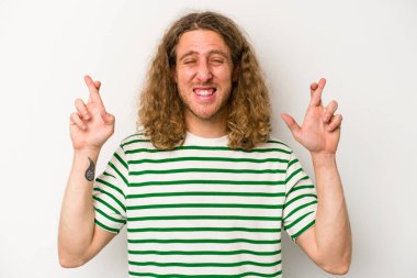 Beyaz arka planda izole genç beyaz adam şans dilemek için şans diliyor.