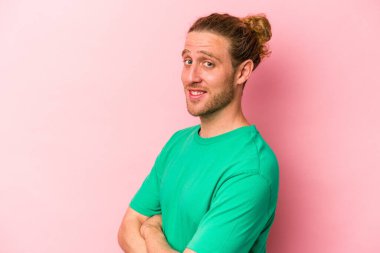 Pembe arka planda izole edilmiş genç beyaz adam mutlu, güler yüzlü ve neşeli.