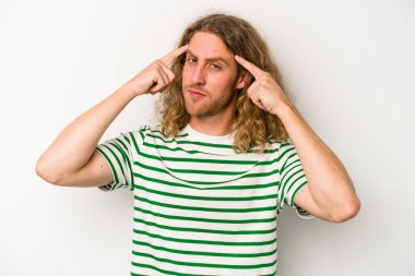 Beyaz arka planda izole edilmiş genç beyaz bir adam bir göreve odaklanmış, işaret parmaklarını işaret ediyor..