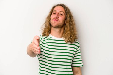 Beyaz arka planda izole edilmiş genç beyaz bir adam selamlama jesti olarak kameraya elini uzatıyor..