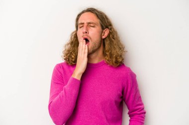 Beyaz arka planda izole edilmiş genç beyaz adam esniyor. Ağzı eliyle kapatan yorgun bir hareket sergiliyor..