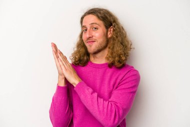 Beyaz arka planda izole olmuş genç beyaz bir adam enerjik ve rahat hissediyor, ellerini ovuşturuyor..