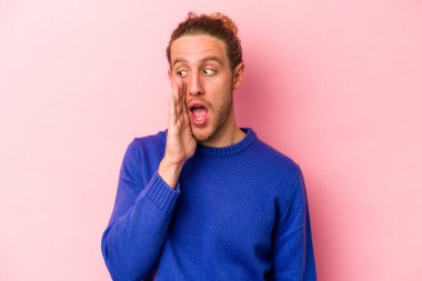 Pembe arka planda izole edilmiş beyaz bir adam heyecanlı bir şekilde bağırıyor..