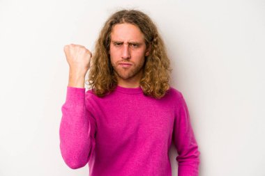 Beyaz arka planda izole edilmiş genç beyaz bir adam yumruğunu kameraya gösteriyor, agresif bir yüz ifadesi..