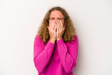 Beyaz arka planda izole olmuş genç beyaz bir adam bir şeye gülüyor, ağızlarını ellerle kapatıyor..