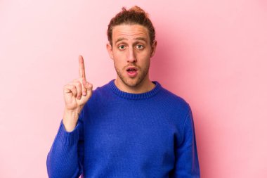 Pembe arka planda izole edilmiş beyaz bir adam ağzı açık bir şekilde üst tarafı işaret ediyor..