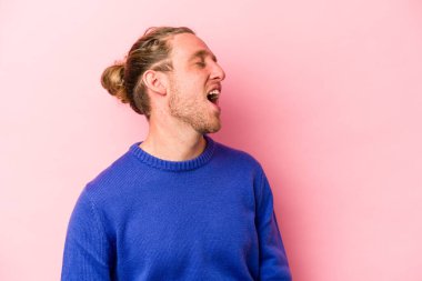 Genç beyaz adam pembe arka planda izole edilmiş dans ediyor ve eğleniyor..