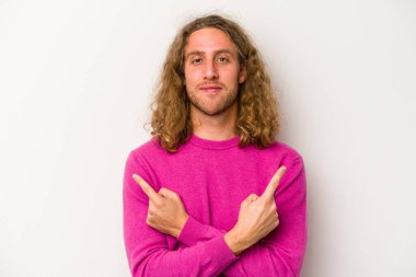 Beyaz arka plan noktalarında izole genç beyaz adam, iki seçenek arasında seçim yapmaya çalışıyor.