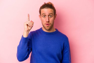 Pembe arka planda soyutlanmış genç beyaz bir adam. Harika bir fikri var, yaratıcılık kavramı..