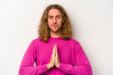 Beyaz arka planda izole edilmiş genç beyaz adam dua ediyor, bağlılık gösteriyor, dindar biri ilahi ilham arıyor..